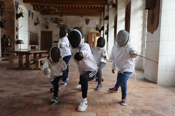 Des enfants au Château de St Fargeau en colo entrain de faire une activité escrime.