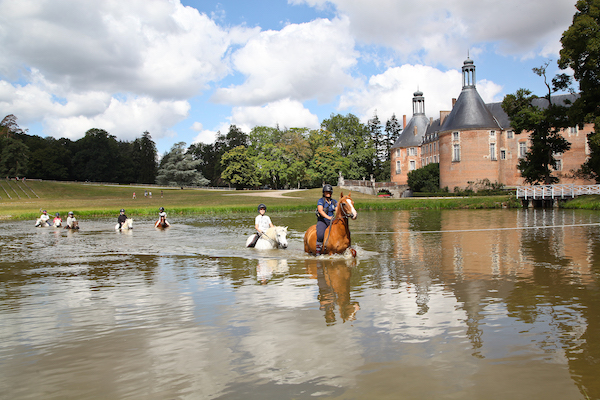 Un groupe d'enfants entrain de faire une activité équitation en colo dans un Château.