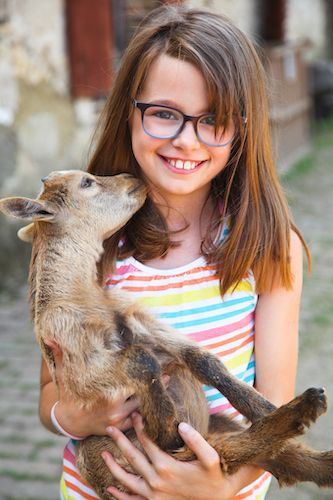 Enfants de 7 ans entrain de s'occuper d'animaux en camps de vacances à la ferme.