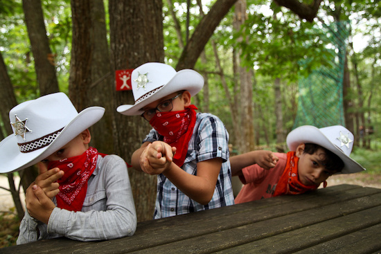 Enfants de 10 ans sur un camp de vacances au FarWest entrain de jouer aux cowboys.