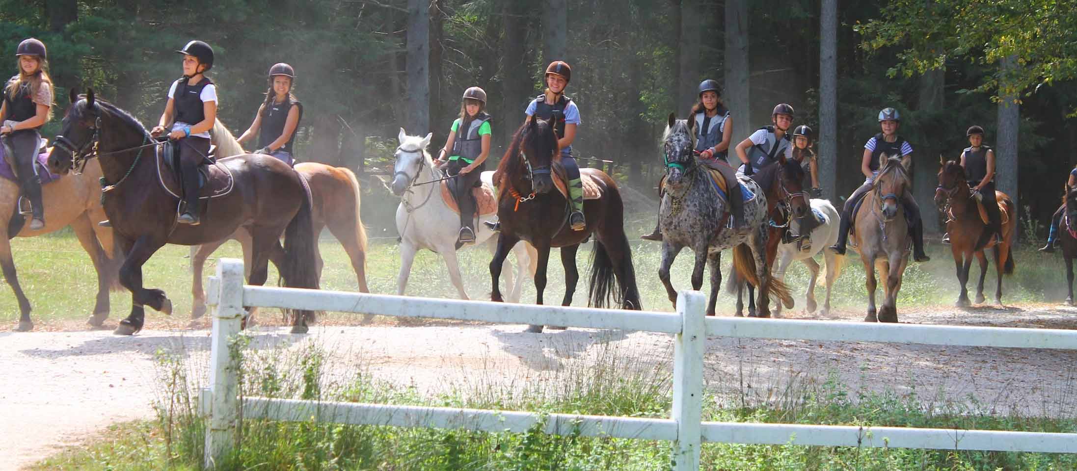 Adolescents sur une colo spéciale équitation avec une randonnée dans la campagne pour découvrir des lieux uniques lors de leur vacances en France durant l'été