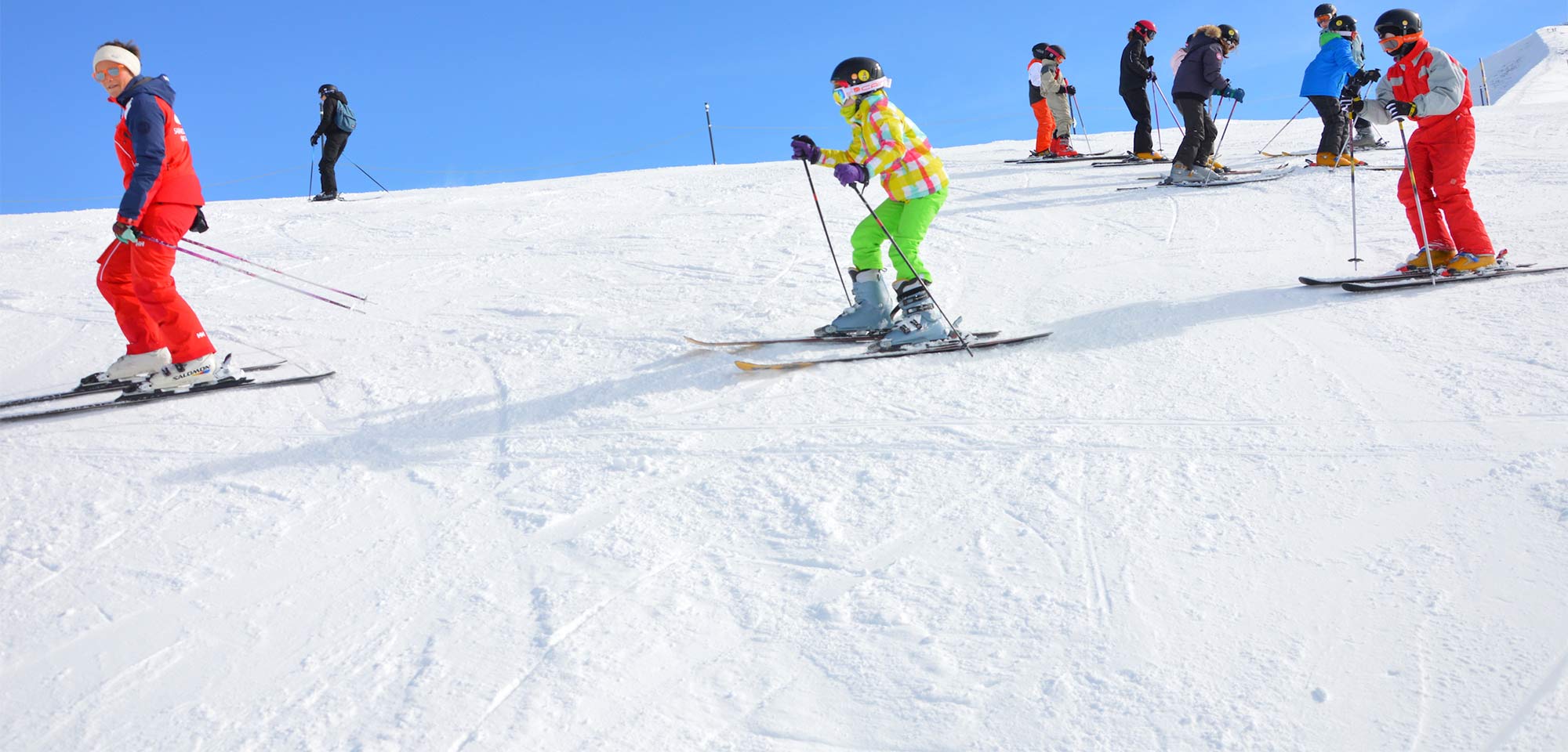 Enfants sur la piste de ski lors d'un camp de vacances dans les montagnes en hiver